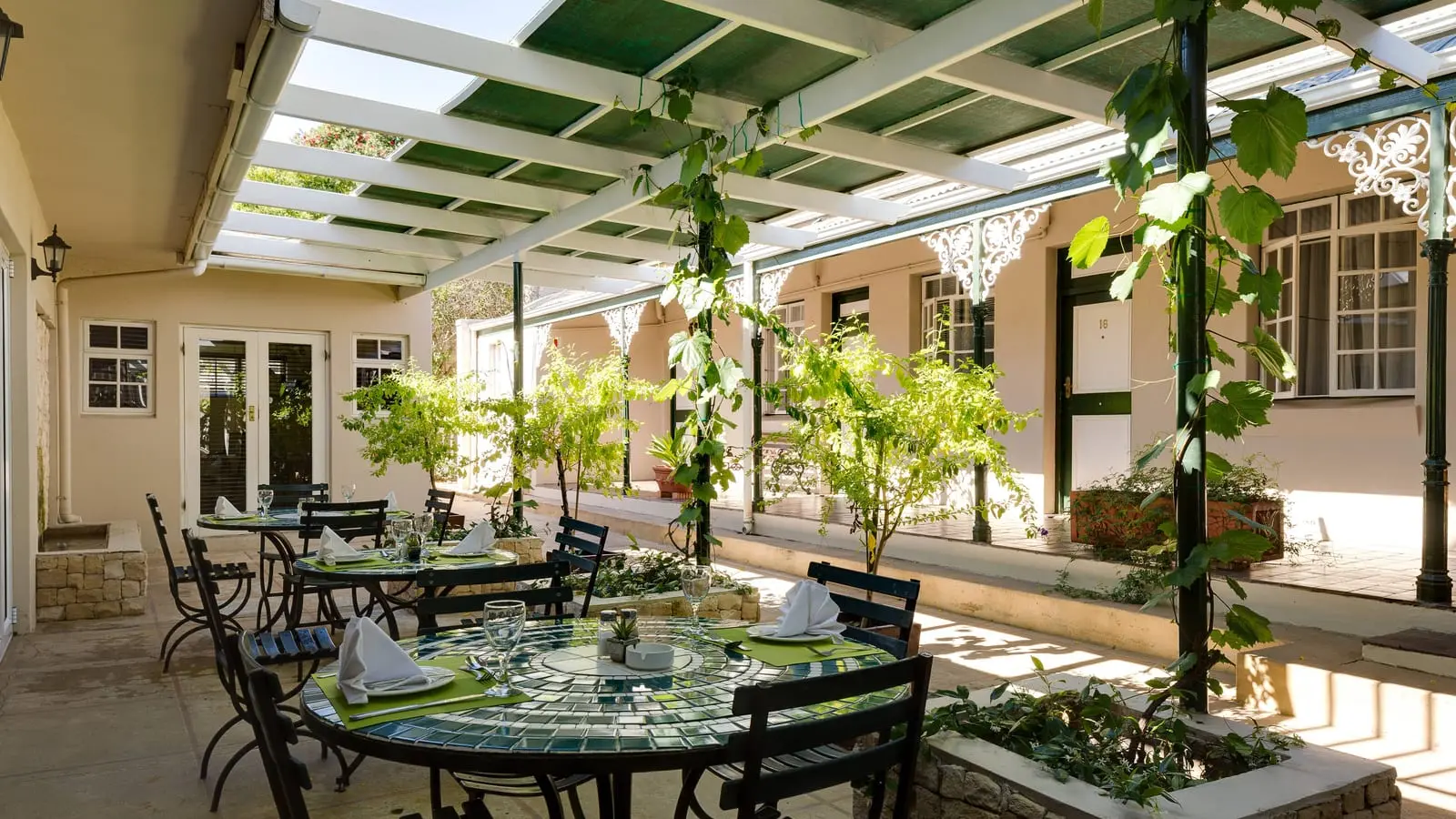 Vine-covered courtyard with dining tables at the Dorpshuis hotel