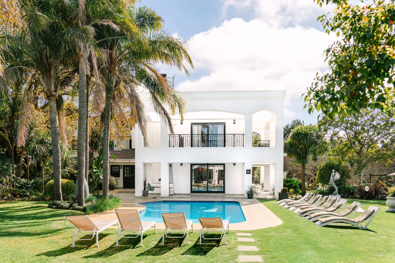 The Salene's white main building and pool, framed by palm trees